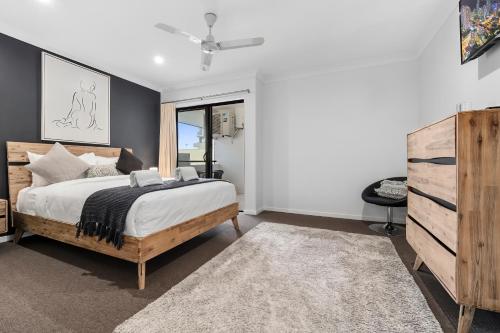 um quarto com uma cama e uma cómoda em Spacious 3 Bedroom Townhouse in Cairns City em Cairns