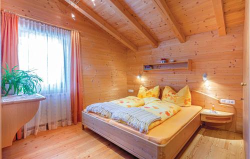 カルティッシュにあるLovely Apartment In Kartitsch With House A Mountain Viewの木製の部屋にベッド1台が備わるベッドルーム1室があります。