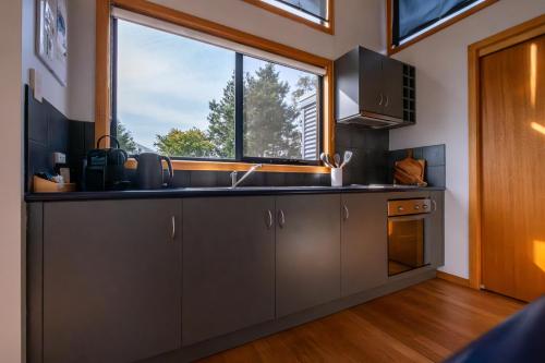 a kitchen with a sink and a window at Beachcomber in Coles Bay