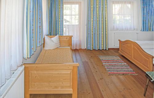 ツェル・アム・ツィラーにあるNice Apartment In Hainzenberg With House A Mountain Viewのベッドルーム1室(ベッド1台、窓2つ付)
