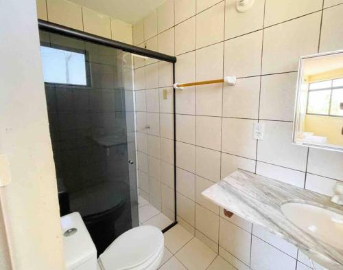a bathroom with a shower and a toilet and a sink at Apartamento na praia da tabuba com vista mar in Caucaia