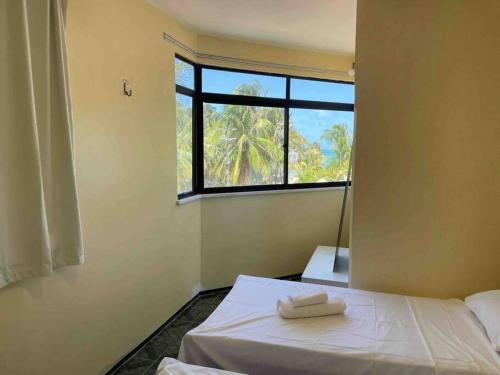 a bedroom with a bed with two towels on it at Apartamento na praia da tabuba com vista mar in Caucaia