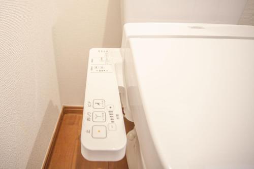 a white remote control in the corner of a refrigerator at Ustay Kitakoiwa in Tokyo