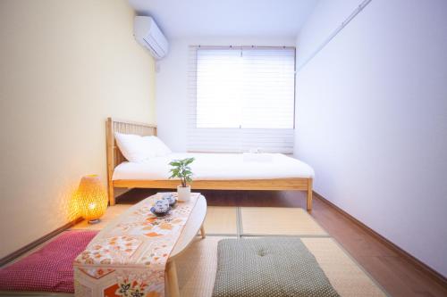 a small room with a bed and a table at Ustay Kitakoiwa in Tokyo