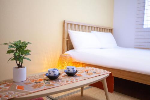a bedroom with a bed and a table with bowls on it at Ustay Kitakoiwa in Tokyo