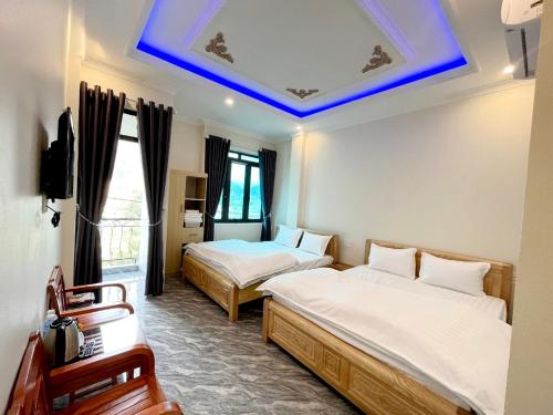 um quarto com 2 camas e um tecto azul em NHÀ NGHỈ ANH VĂN em Dong Van