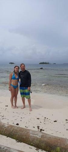 a man and a woman standing on the beach at Isla Diablo San blas cabaña en la orilla del mar in Cagantupo