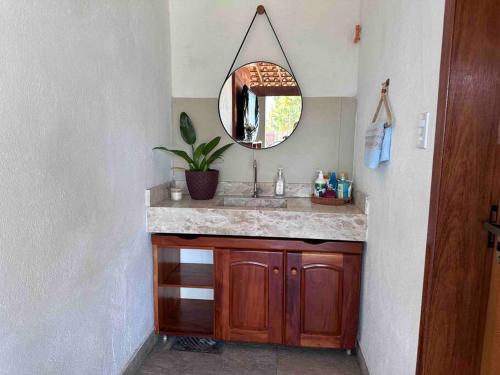 a bathroom with a sink and a mirror at Paraíso PÉ NA AREIA no coração do litoral norte in Ilhéus