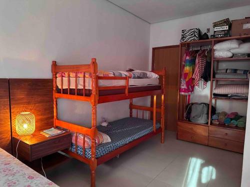 a room with two bunk beds and a lamp at Paraíso PÉ NA AREIA no coração do litoral norte in Ilhéus