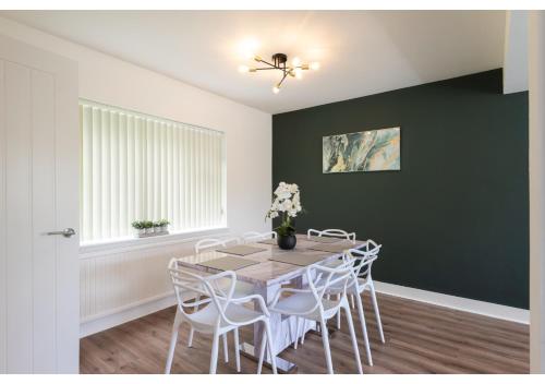 a dining room with a table and white chairs at Cozy 3 BD House, Perfect for Large Group of 6 in Manchester