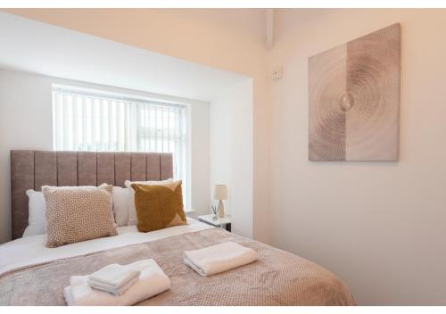 a bedroom with a large bed with two towels on it at Cozy 3 BD House, Perfect for Large Group of 6 in Manchester