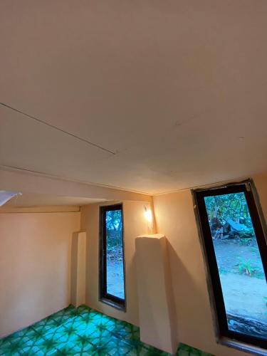 an empty room with two windows and green tiles at Koh Phu Valley in Ko Jum