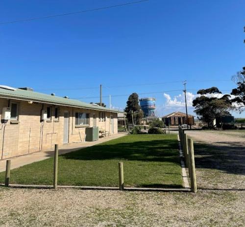 a fence in a field next to a building at Tuckerway - Beach Stay Property for Large Groups! in Port Vincent