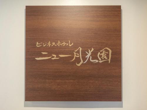 a wooden door with a writing on it at Tabist New Gekkoen in Shimminatomachi