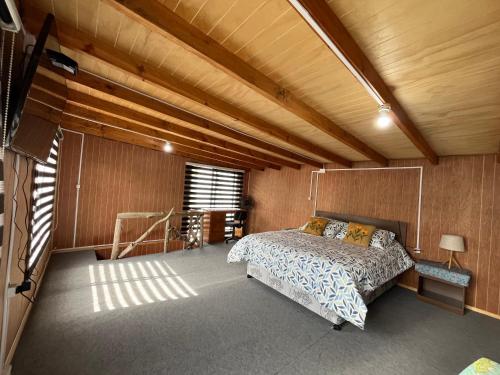 a bedroom with a bed in a room with wooden walls at Cabaña Kora in Puerto Fuy