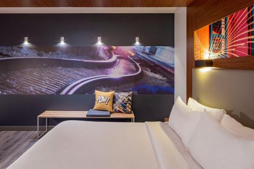 a hotel room with a bed and a painting on the wall at Aloft New Orleans Downtown in New Orleans