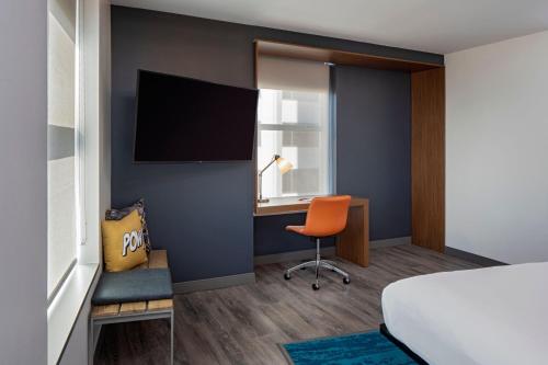 a hotel room with a bed and a desk and a chair at Aloft New Orleans Downtown in New Orleans
