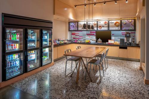 a restaurant with a table and chairs and a refrigerator at Aloft New Orleans Downtown in New Orleans