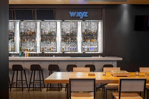 a bar with wooden tables and chairs in a restaurant at Aloft New Orleans Downtown in New Orleans