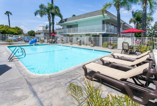 einen Pool mit Liegestühlen und ein Gebäude in der Unterkunft Motel 6-Rosemead, CA - Los Angeles in Rosemead