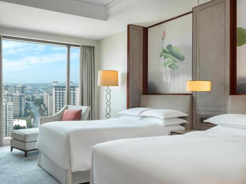 嘉定区にあるシェラトン 上海 嘉定 ホテルのベッド2台と窓が備わるホテルルームです。