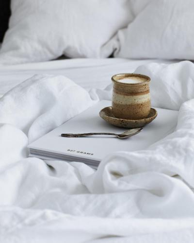 a plate with a cup and a spoon on a bed at Le Viti Barn in Newrybar