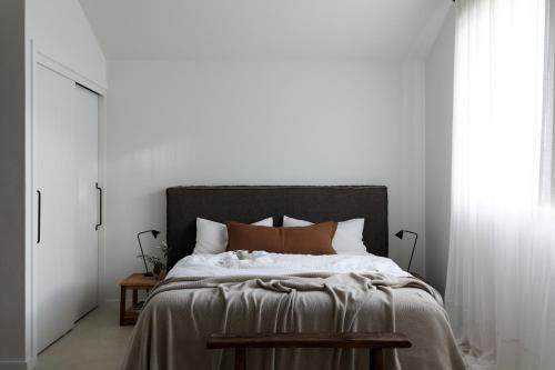 a bedroom with a large bed with white walls at Le Viti Barn in Newrybar
