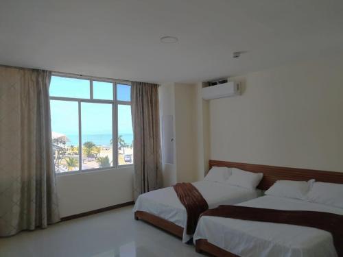 a hotel room with two beds and a large window at Turqueza Home in Esmeraldas