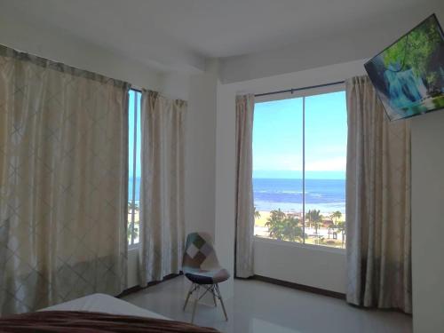 a bedroom with a large window with a view of the ocean at Turqueza Home in Esmeraldas