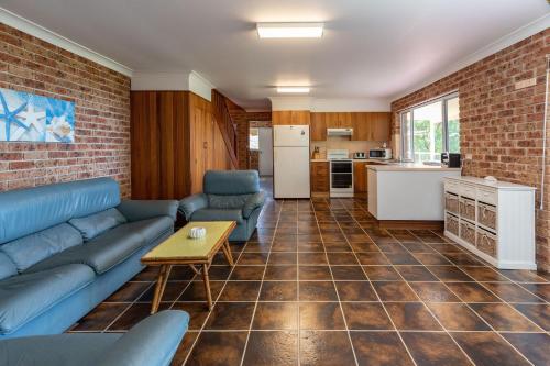 a living room with a couch and a table at Coastal Cove in Smiths Lake