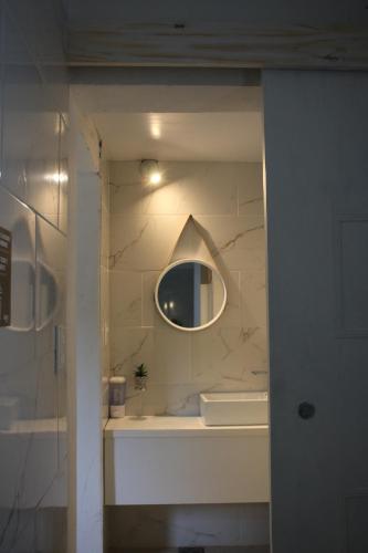 baño con espejo y lavabo en BROTHERS HOSTEl en Villa Allende