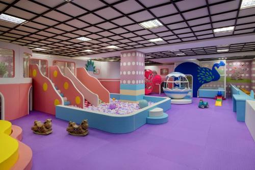 a pink and purple room with a pool and a slide at Sheraton Grand Xishuangbanna Hotel in Jinghong