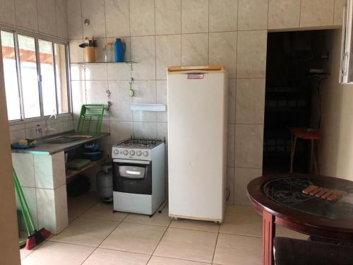 eine kleine Küche mit einem Herd und einem Kühlschrank in der Unterkunft Apartamentos Ilha Comprida in Ilha Comprida