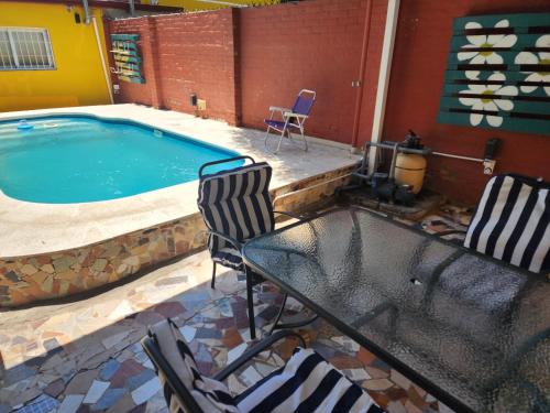 una piscina con sillas, una mesa y una mesa con sillas en Casa en Santiago del Estero Capital en Santiago del Estero