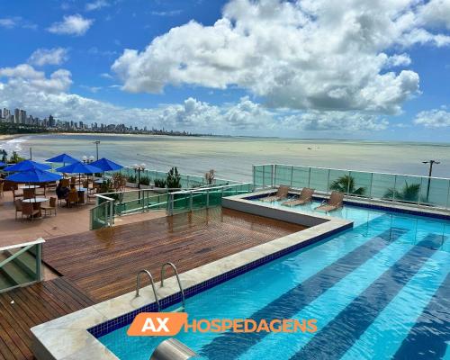 a swimming pool with a view of the beach at AX Blue Suítes in João Pessoa