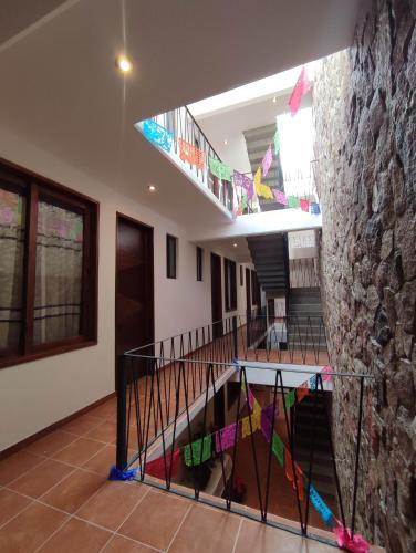 a hallway with a stone wall and stairs with kites at Casa Mictlan. Habitaciones en el Centro de Mitla. in San Pablo Villa de Mitla