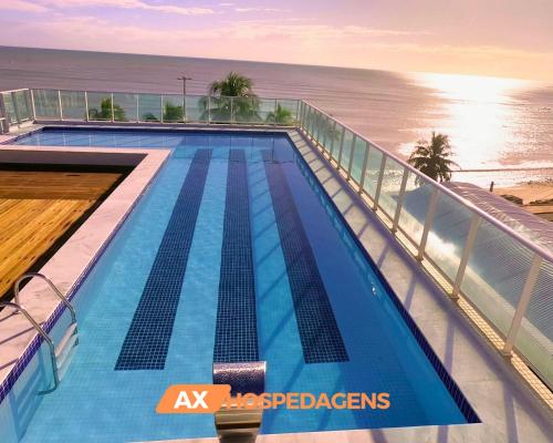 a swimming pool on top of a building next to the ocean at AX Blue Suítes in João Pessoa