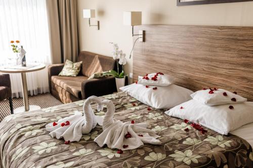 two swans towels are on a bed in a hotel room at Hotel La Siesta & Medical Spa in Jastrzębia Góra