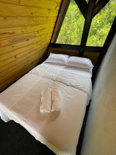 a bed in a room with two white pillows at Chalé Panorama in Munhoz