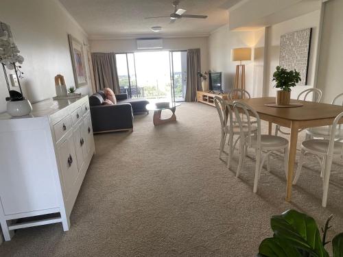 a living room with a table and a dining room at Rovera Apartments in Maroochydore