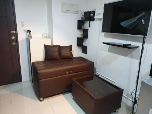 ein Wohnzimmer mit einem Sofa und einem Flachbild-TV in der Unterkunft Baguio Bliss by Burnham Hill Condominium in Baguio City