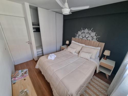 a bedroom with a large bed with a white bedspread at Mi Lugar en Rosario - Depto céntrico VIP, 3 amb con cochera opcional in Rosario
