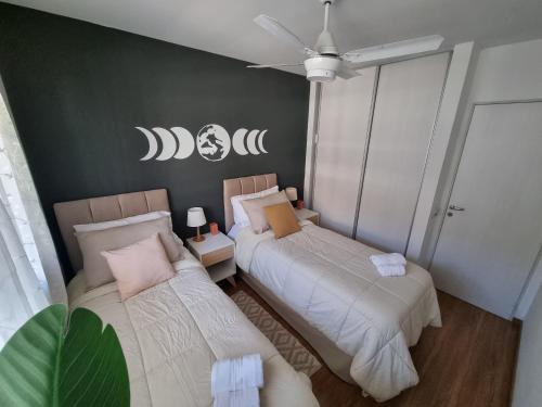 a bedroom with two beds and a green wall at Mi Lugar en Rosario - Depto céntrico VIP, 3 amb con cochera opcional in Rosario