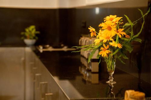 a vase of yellow flowers on a counter in a kitchen at AGP Greeny View Resident in Galle