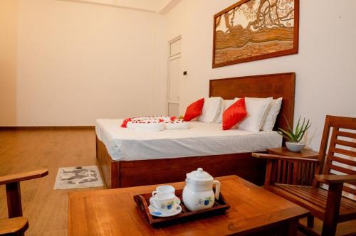 a room with a bed and a table with a tray of teaitures at AGP Greeny View Resident in Galle