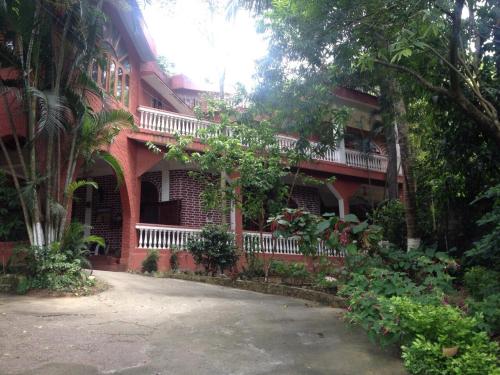 a red brick building with a balcony on it at Hilltop Lodge in Guwahati
