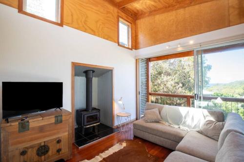 a living room with a couch and a flat screen tv at Sea View + Sleeps 8 + 3 mins to Beach in Point Lookout