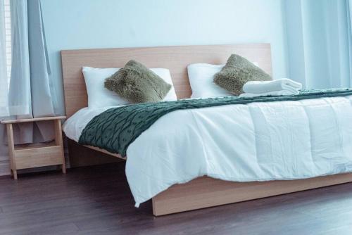 een bed met witte lakens en groene kussens bij Spacieux Appartement de 3 Chambres downtown in Montreal