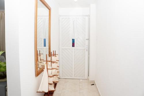 un couloir avec une porte blanche et un miroir dans l'établissement La Niña Mire, à Puerto Colombia