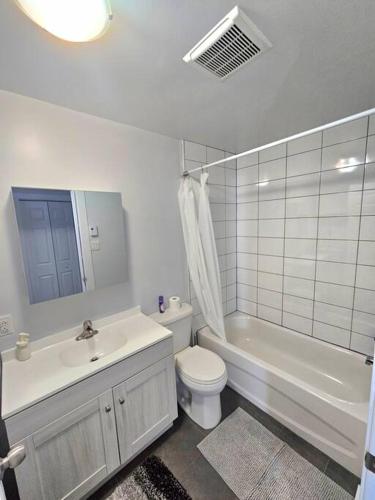 a bathroom with a toilet and a sink and a tub at Spacieux Appartement de 3 Chambres downtown in Montréal